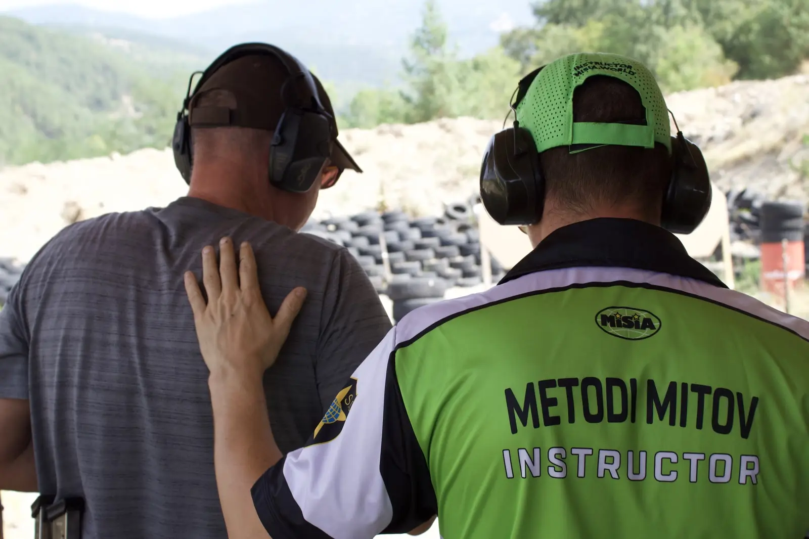 An instructor briefing two guests before they shoot